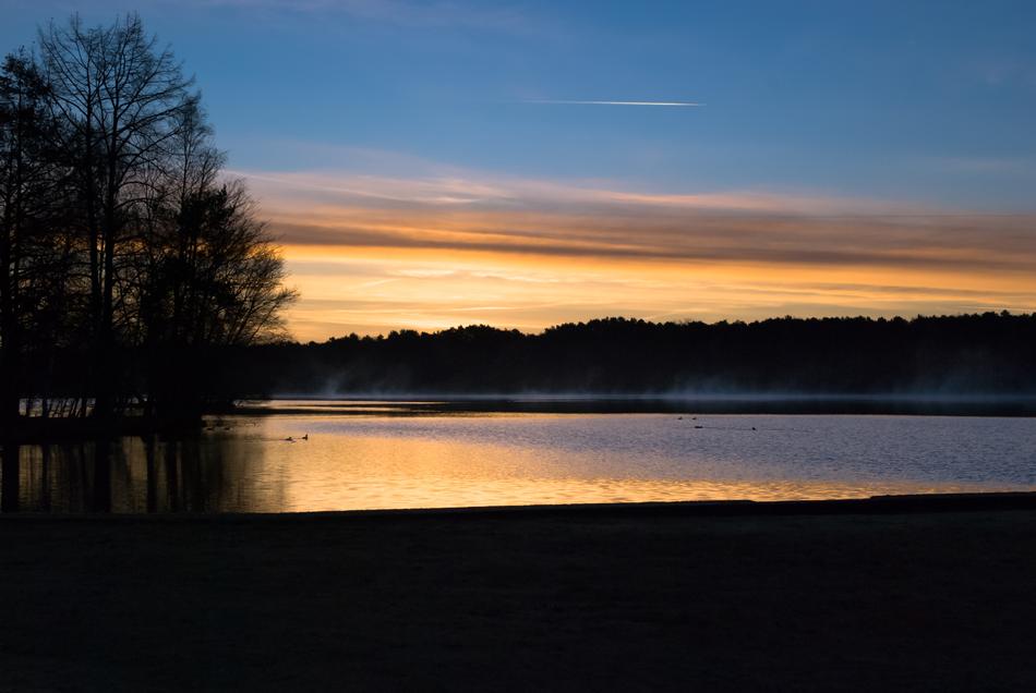 Landscape of the beautiful lake among the trees, at colorful and beautiful twilight
