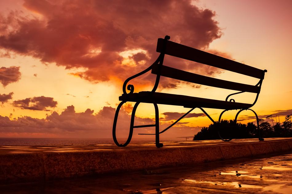 red sunset in the clouds over the bench