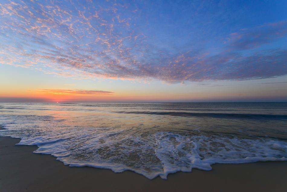 sunset over the sea surf on the sand
