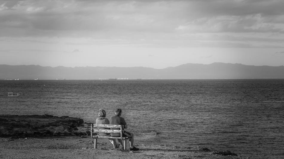 couple on bench overlooking the sea