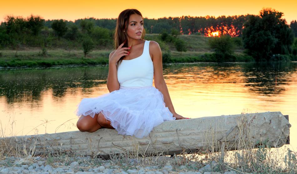 girl in white at sunset on the lake
