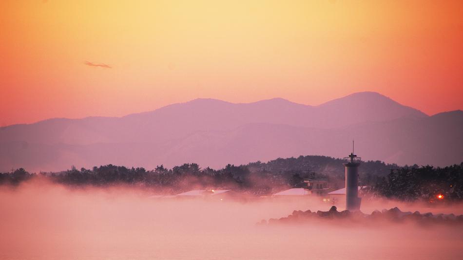 scenic sunset over coastal city covered with fog, south korea, gangneung
