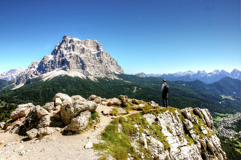 Wanderer on the beautiful Dolomites, with green plants and rocks, in sunlight, in Italy