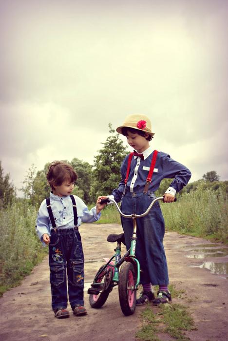 brothers with a bicycle on a rural road