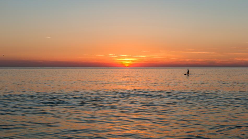 Beautiful waterscape of the sea with boat, on Sylt, Germany, at colorful and beautiful sunset