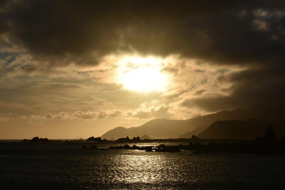 dark clouds over the sea and mountains at dusk