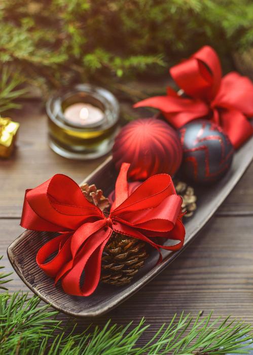 Beautiful and colorful Christmas decorations among the green Christmas trees, on the wooden table