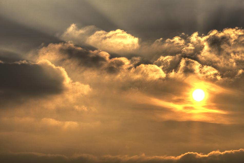 Beautiful and colorful Sun, among the clouds in the sky