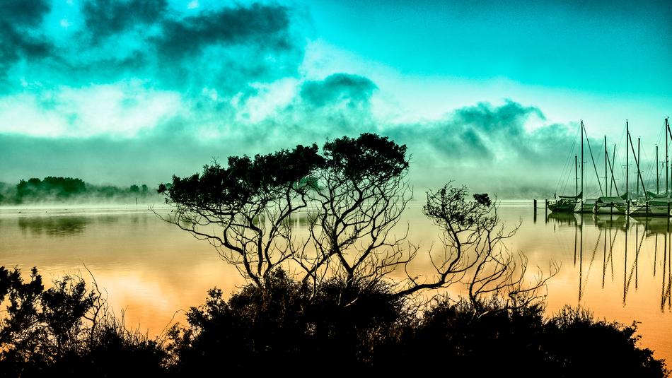 turquoise sky over dark silhouettes at sunset