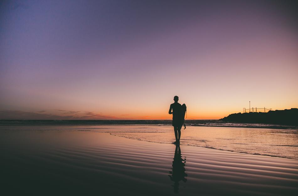 Beautiful landscape of the beach with silhouette of the man, at colorful and beautiful sunset