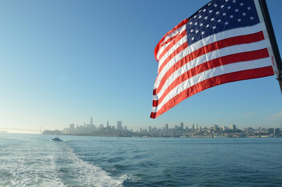 American flag on a yacht against the backdrop of the San Francisco coast
