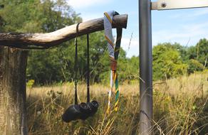 binoculars and a scarf on a wooden fence in the forest