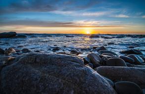 large stones on the sea coast during sunset