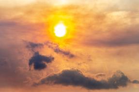 Beautiful and colorful Sun at sunset among the clouds, in the evening