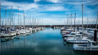 yachts at the pier against the background of blue sky and white clouds