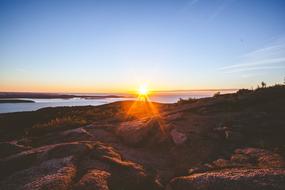 bright sun over the rocky coast at dusk
