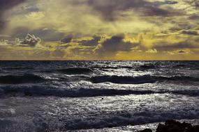 Beautiful, shiny waterscape of the sea with waves, in light, in Ayia Napa, Cyprus, at colorful and beautiful sunset