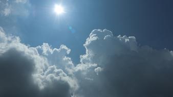 Beautiful, blue sky with white and grey clouds in sunlight, on the view from the plane