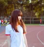 Asian girl on the track among the other people and colorful trees