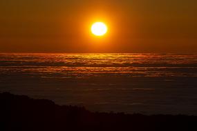bright sun at sunset over water at dusk