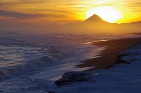 Beautiful and colorful beach of the Pacific Ocean, with mountains, at colorful and beautiful sunrise