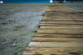 Close-up of the wooden path on the sandy beach