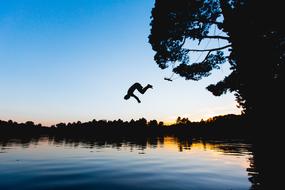 person Jumping into water at dusk