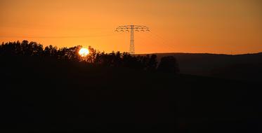Beautiful landscape with silhouettes of the trees and power poles, at colorful and beautiful sunset