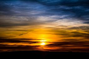 Beautiful and colorful sunset behind the dark clouds, in the evening