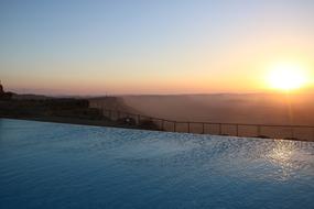 Beautiful landscape with the hotel pool, on the mountains, at colorful and beautiful sunset on horizon
