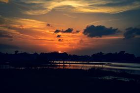 Beautiful landscape with the water among the plants, at colorful and beautiful sunset with clouds