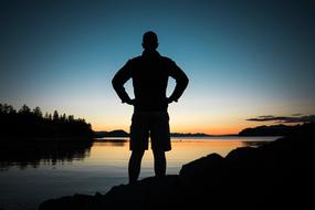 silhouette of a man on the coast at dark twilight