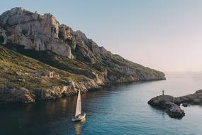 sailboat sails near the island