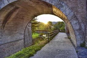 Beautiful bridge above the river, among the plants, in Umbertide, Italy, at colorful and beautiful sunset