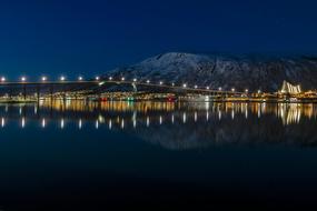 Beautiful and colorful coast of the water, with colorful lights, buildings and mountain, in the evening