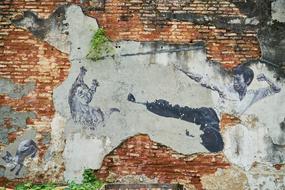 Old, colorful wall with graffiti and green plants