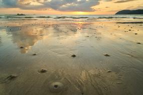 Beautiful landscape of the beach with water, at colorful and beautiful sunset among the clouds