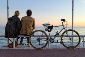 couple with bike on the waterfront of nice