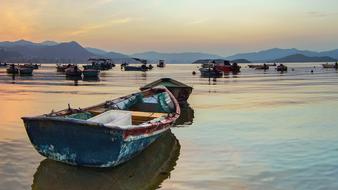 Colorful boats on the sea, among the mountains, at colorful and beautiful sunset