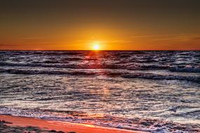 Sunset, red beams over Sea Waves