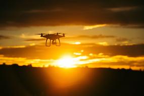 flying drone on the background of golden sunset