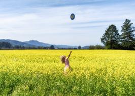 girl with a balloon on a field with a flowering plant