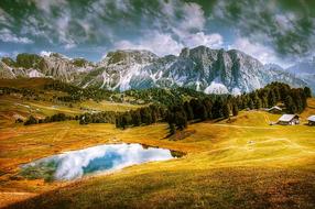 Beautiful and colorful landscape of Val Gardena Dolomites with plants and water, in Italy, under the clouds