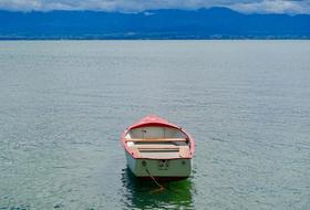 Colorful boat on the beautiful waterscape with ripple, near the mountains