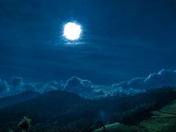 bright moon over the hills at night