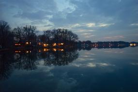Beautiful coast of the lake with plants and lights, at beautiful sunset with clouds