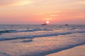 ship at sea under pink sky during sunset
