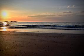 Beautiful sandy beach of the sea, at colorful and beautiful sunset among the clouds