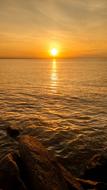 yellow sun on the horizon above the water at dusk