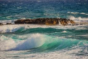 Beautiful and colorful waterscape with shoal in the water with waves, in sunlight